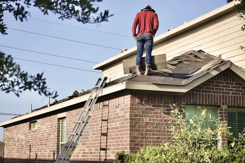 Professional roofer working on a residential roof in Oxboro